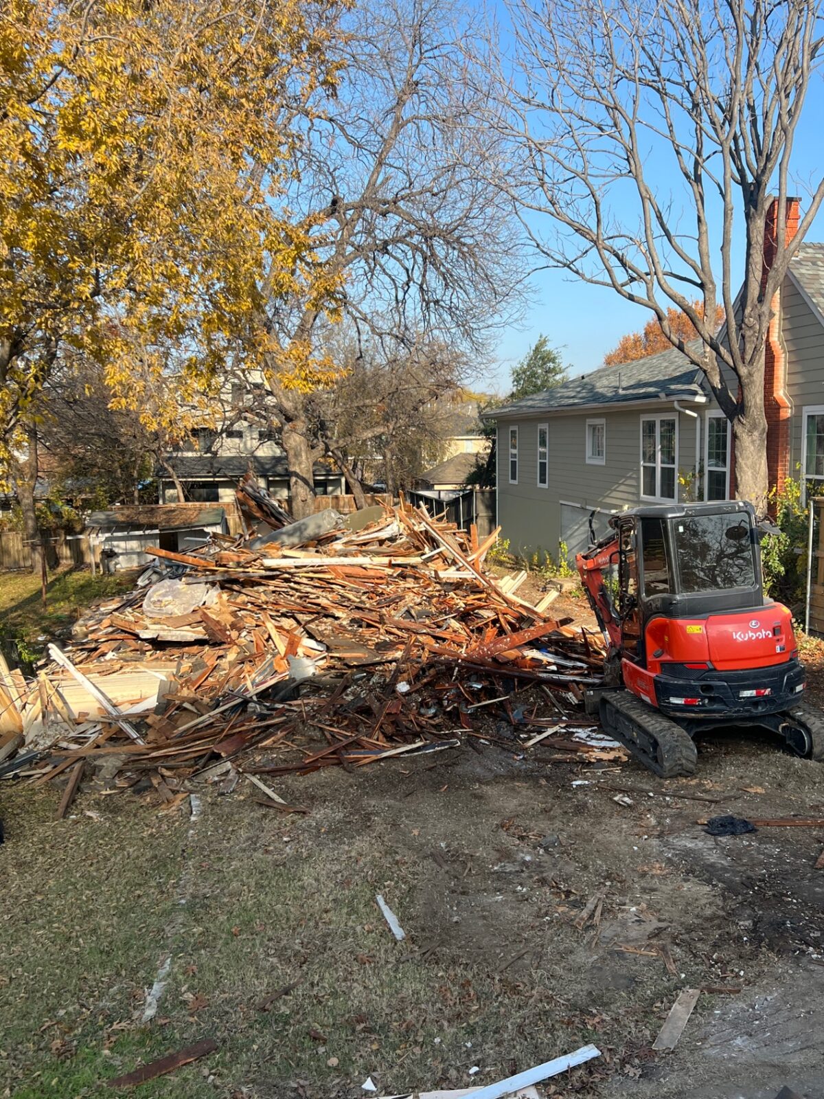 Demolition debris pile with excavator