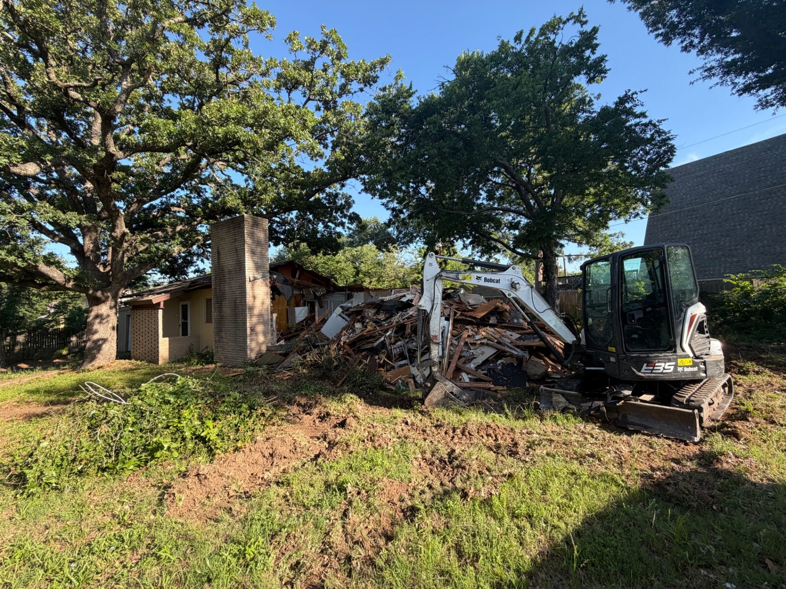 Excavator tearing down a house