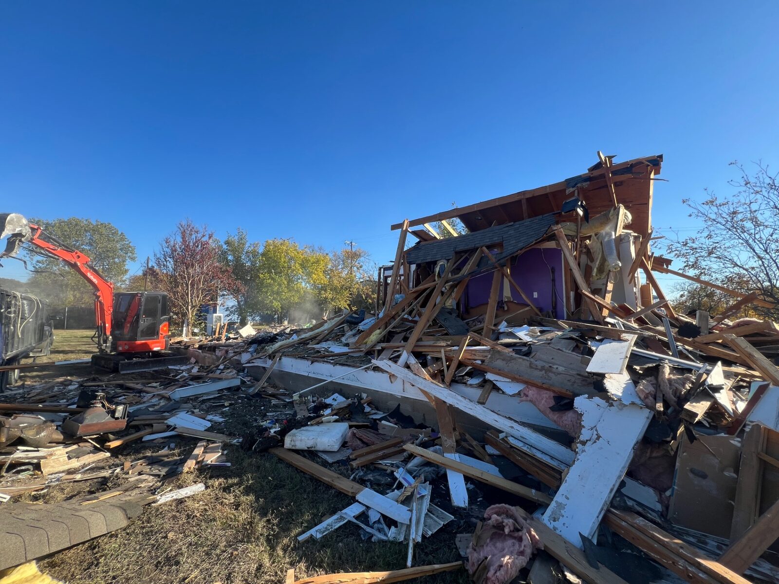 Excavator tearing down a house