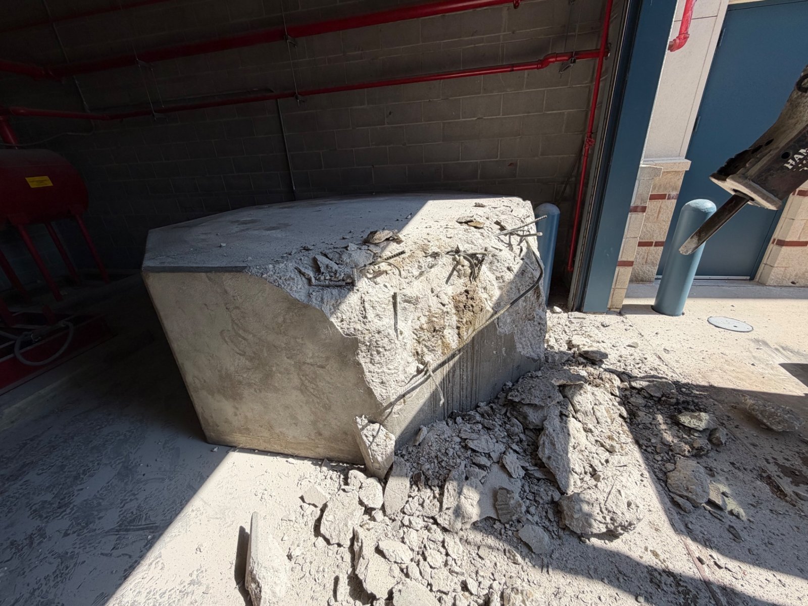 Concrete base being demolished in a mechanical room