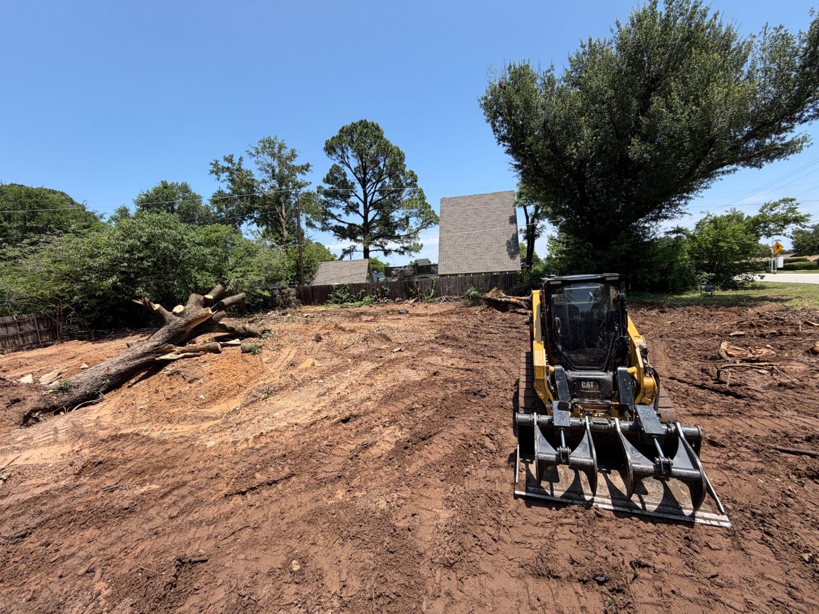 Skid steer grading a cleared lot