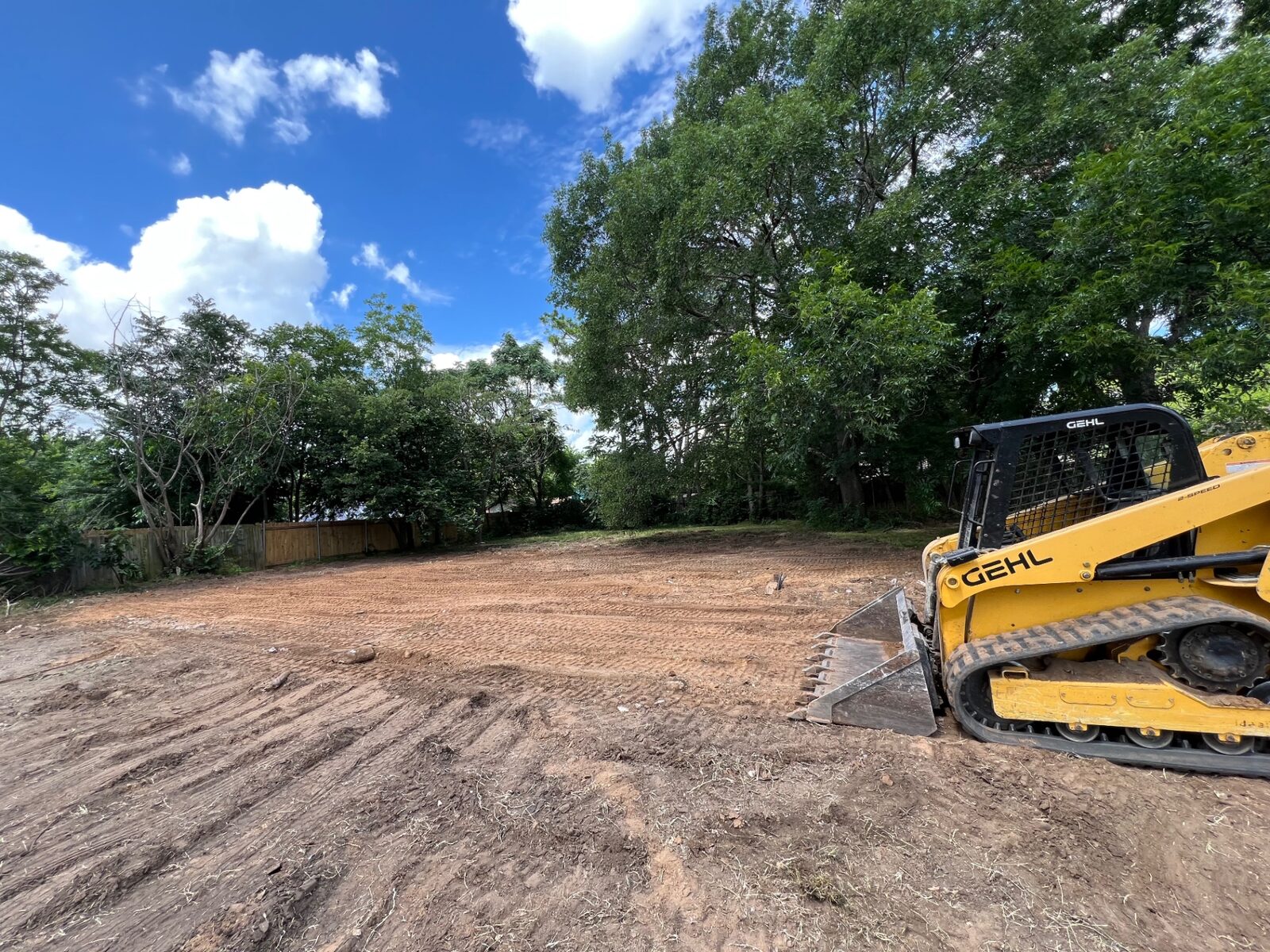 Skid steer finishing a cleared site